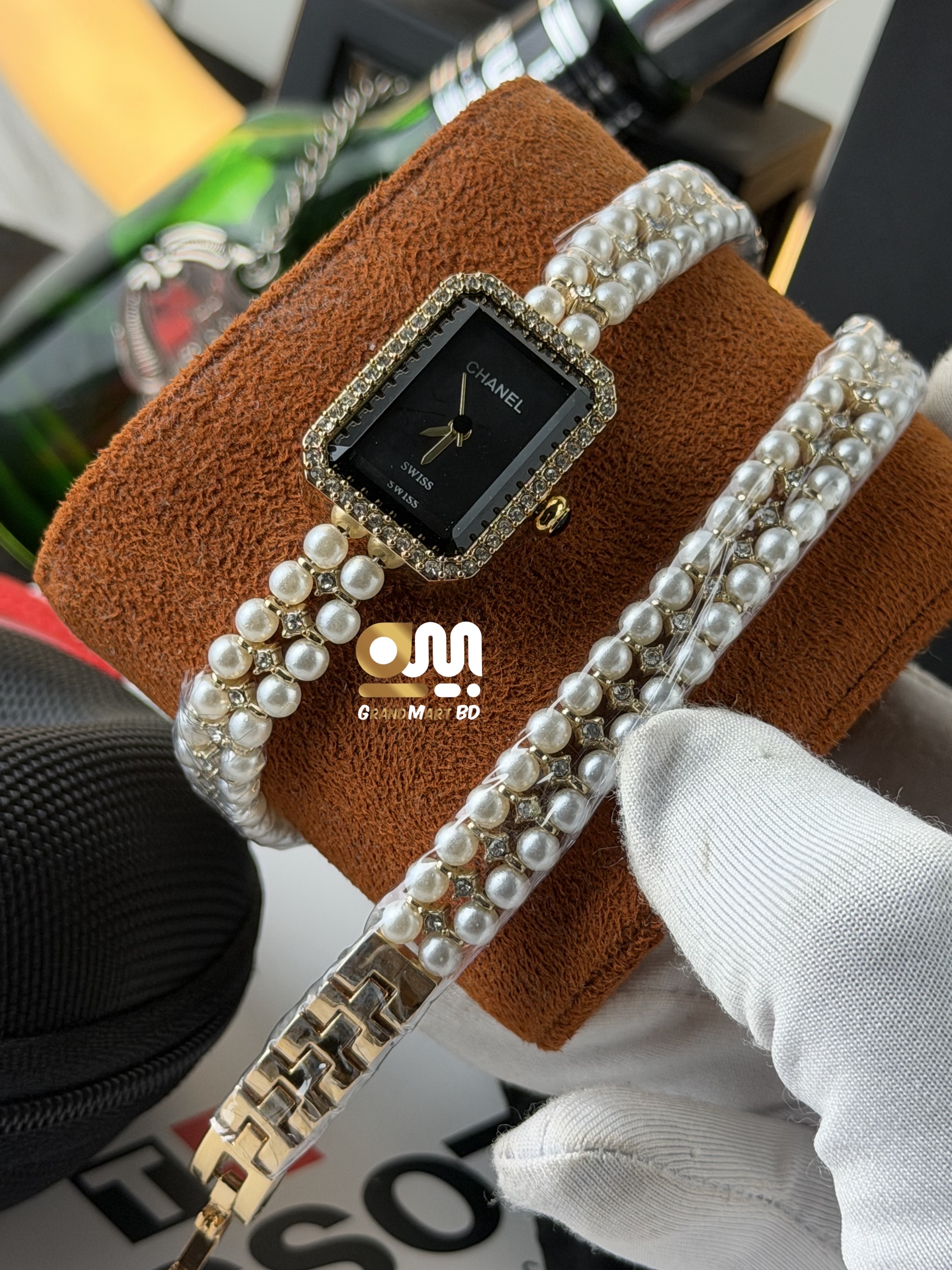 Chanel-branded quartz ladies' fashion watch featuring a rectangular black dial, a crystal-embellished bezel, and a multi-strand faux pearl and gold-tone bracelet band.