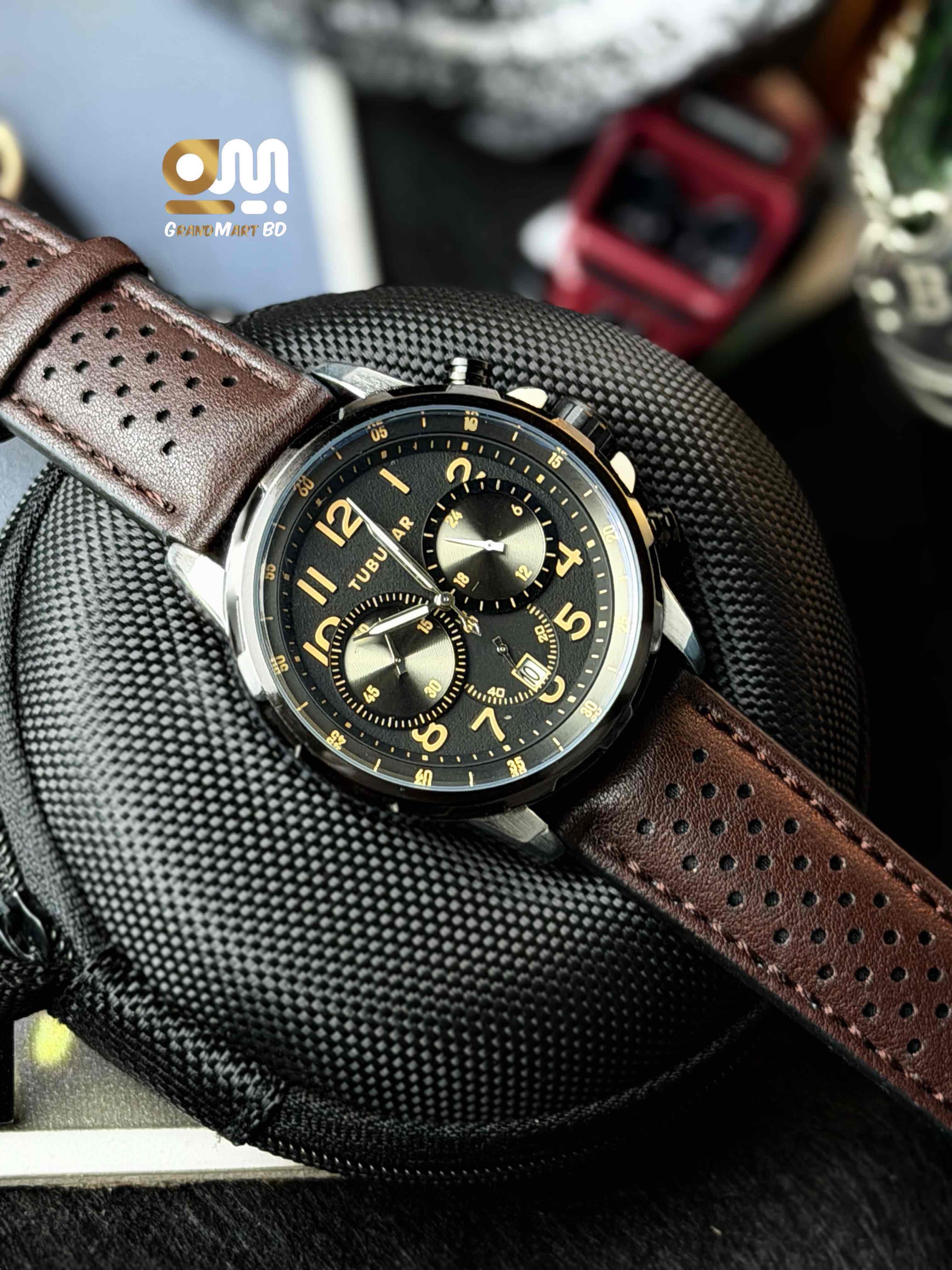 Tubular Analog Quartz Chronograph Watch featuring a dark textured dial with orange numerical markers and a perforated brown leather strap