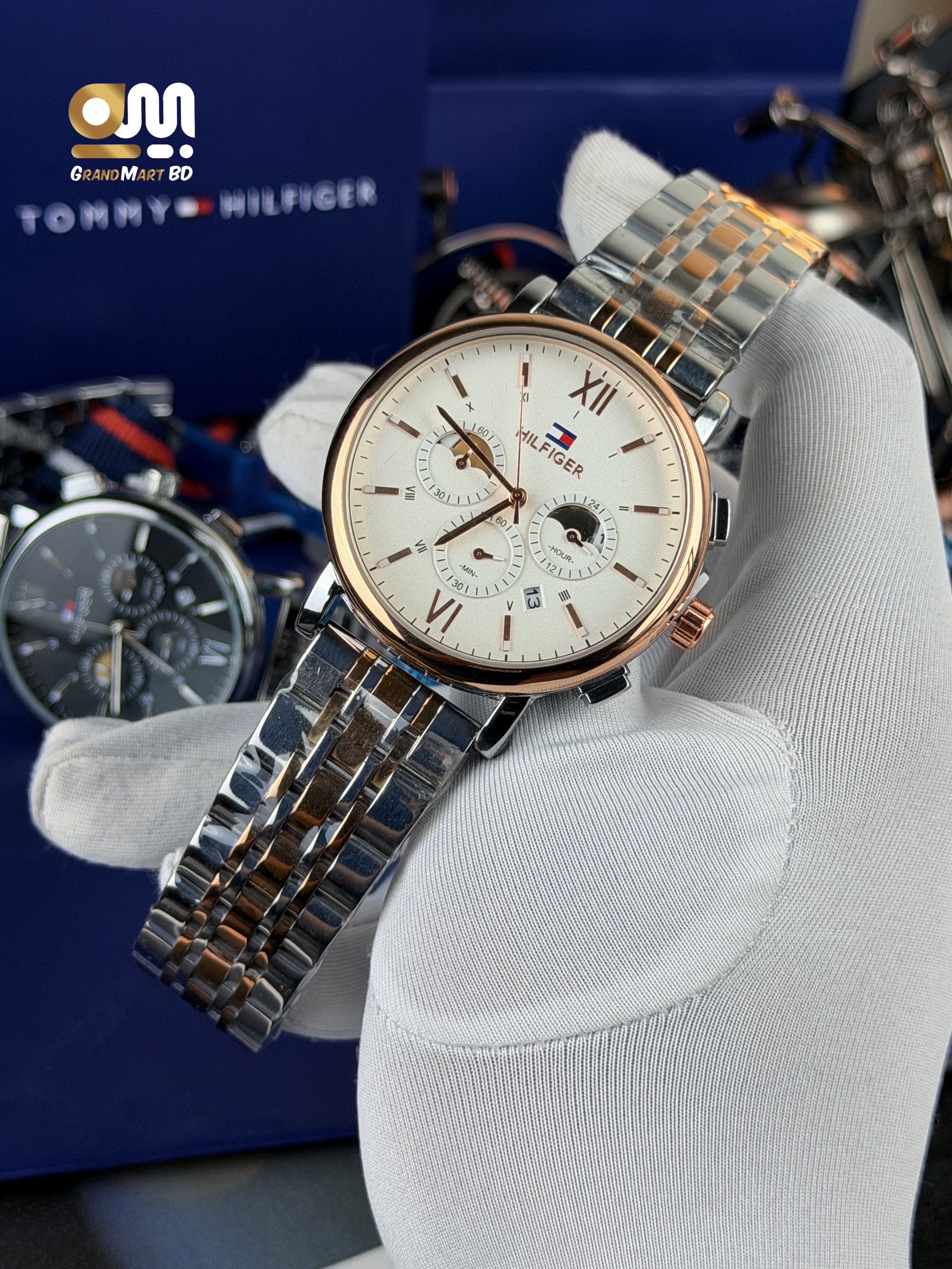 Tommy Hilfiger men's analog wristwatch with a rose-gold-toned bezel, white/cream dial, multi-function sub-dials, and a two-tone stainless steel (silver and rose-gold) link bracelet.