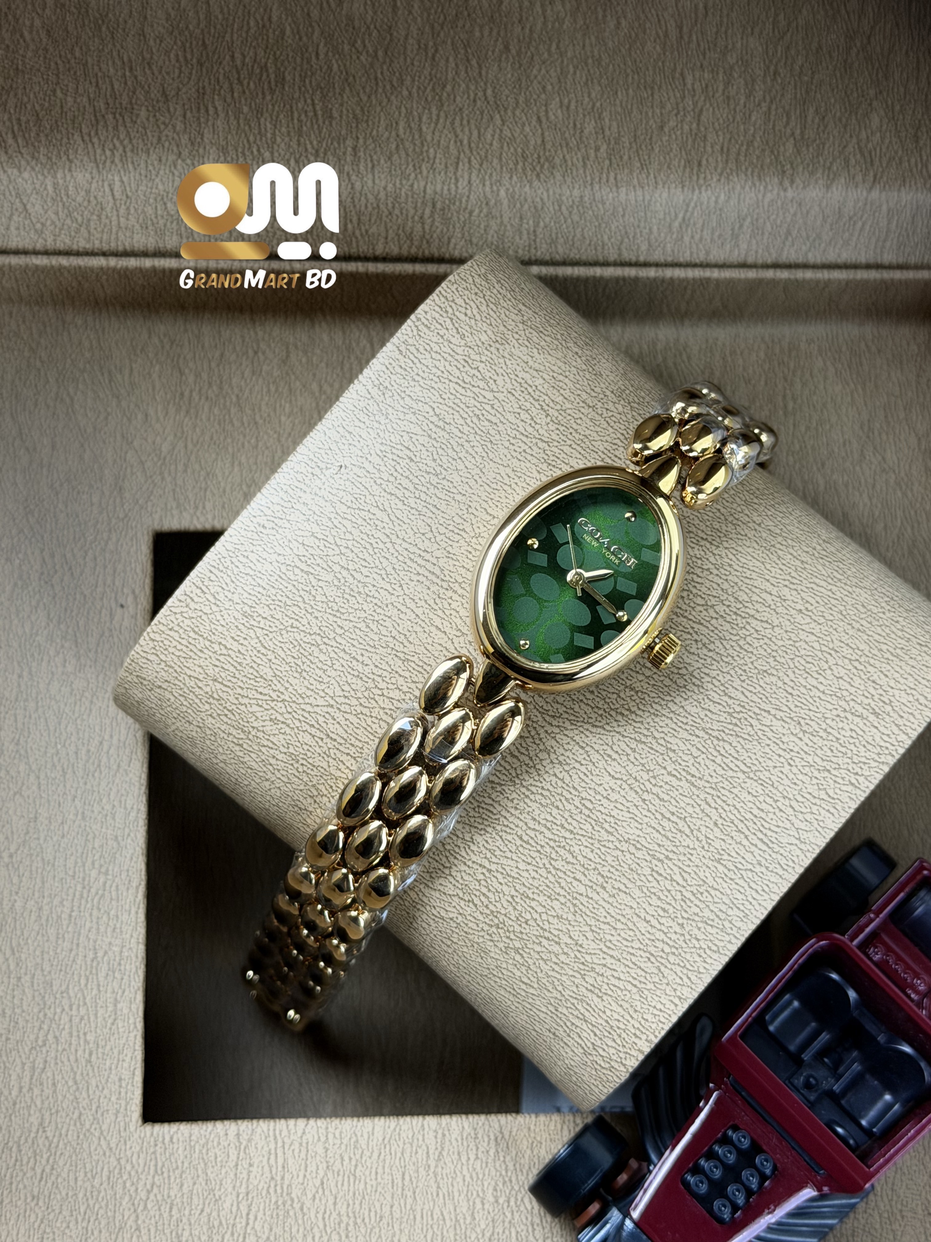 Coach Sammy gold-tone women's watch featuring a slim oval green signature dial.