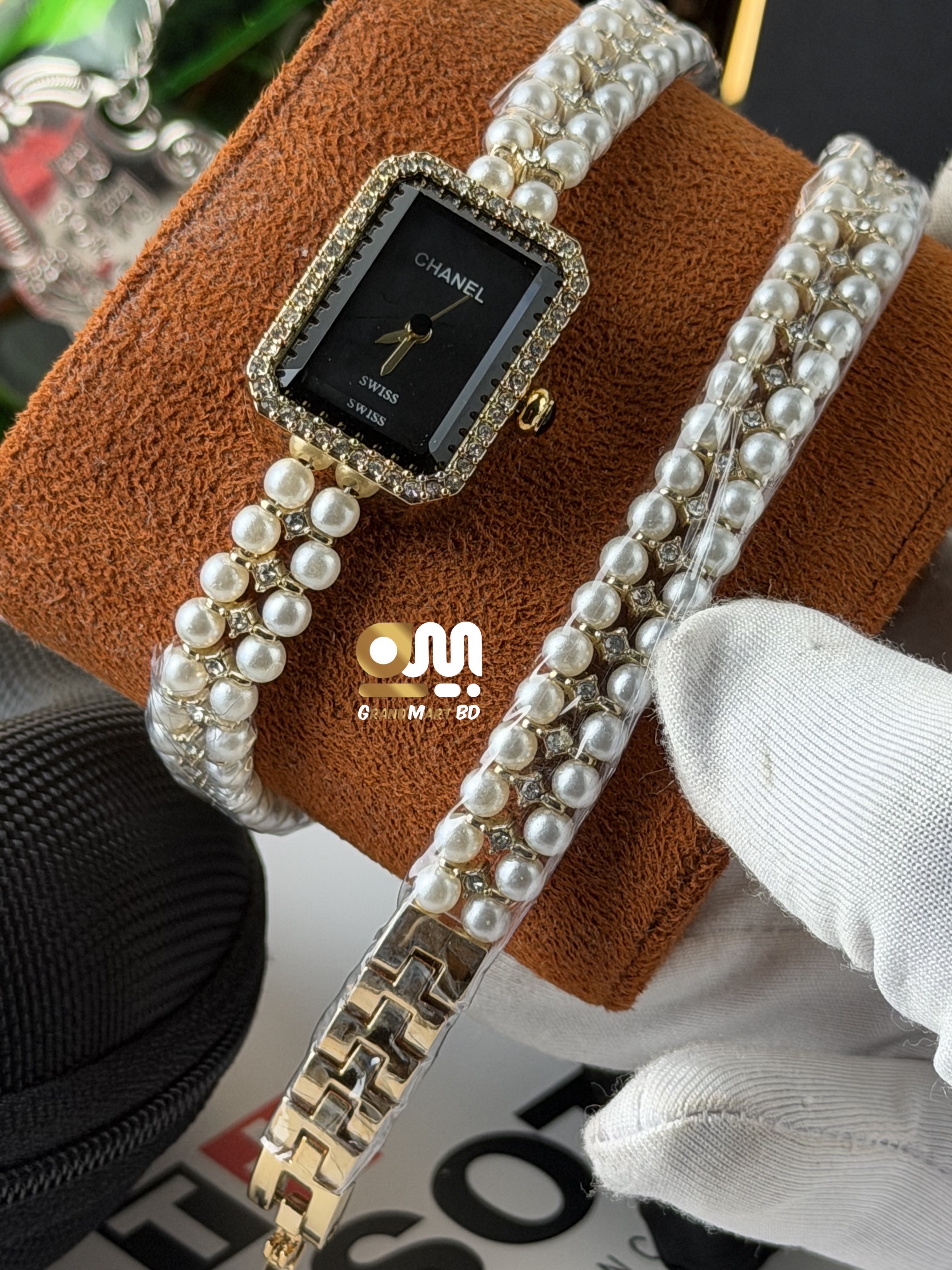 Chanel-branded quartz ladies' fashion watch featuring a rectangular black dial, a crystal-embellished bezel, and a multi-strand faux pearl and gold-tone bracelet band._img_1