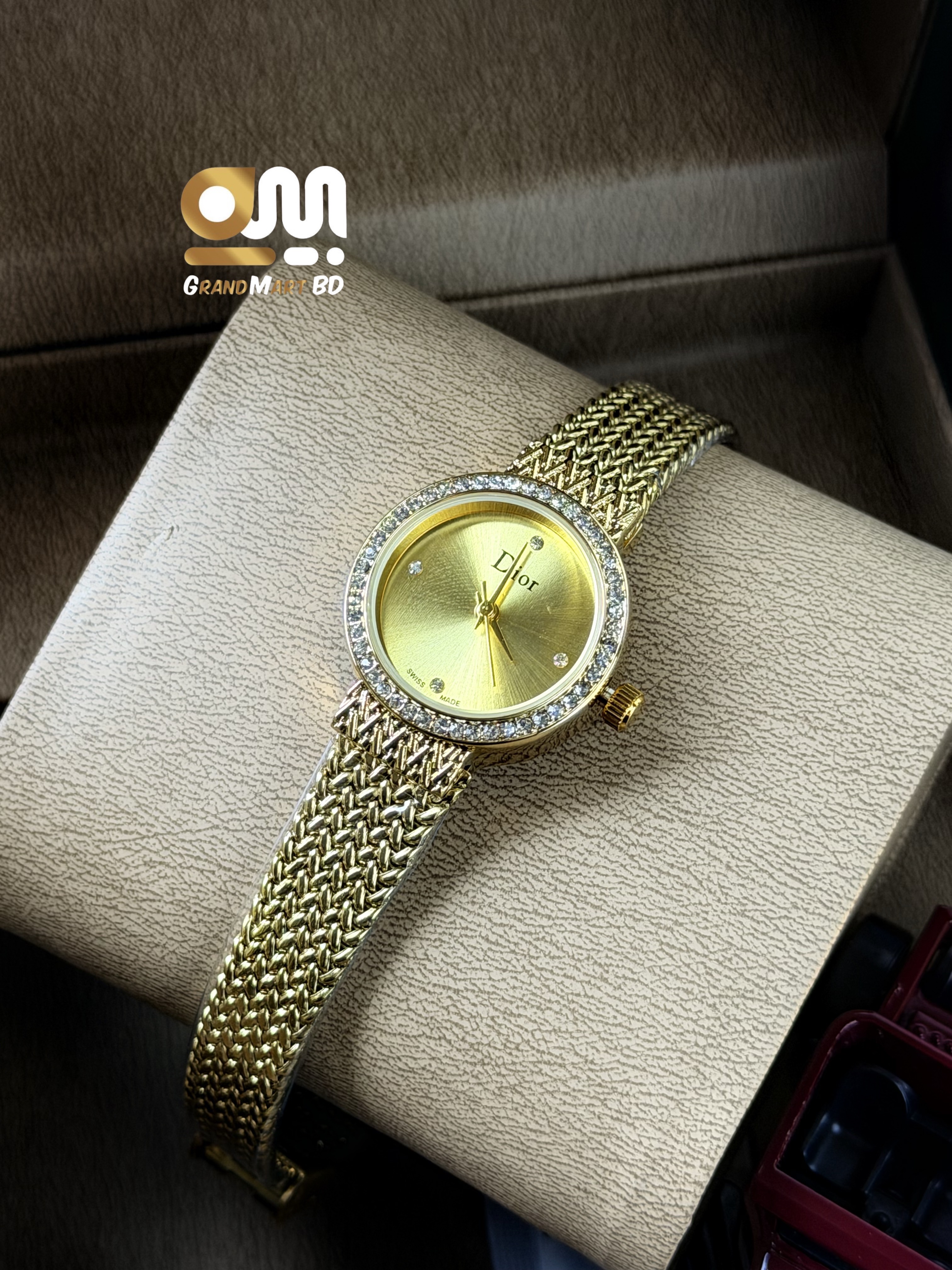 Dior La D de Dior women's gold-tone mesh/ribbon bracelet watch featuring a round sunburst gold dial and a crystal-set bezel.