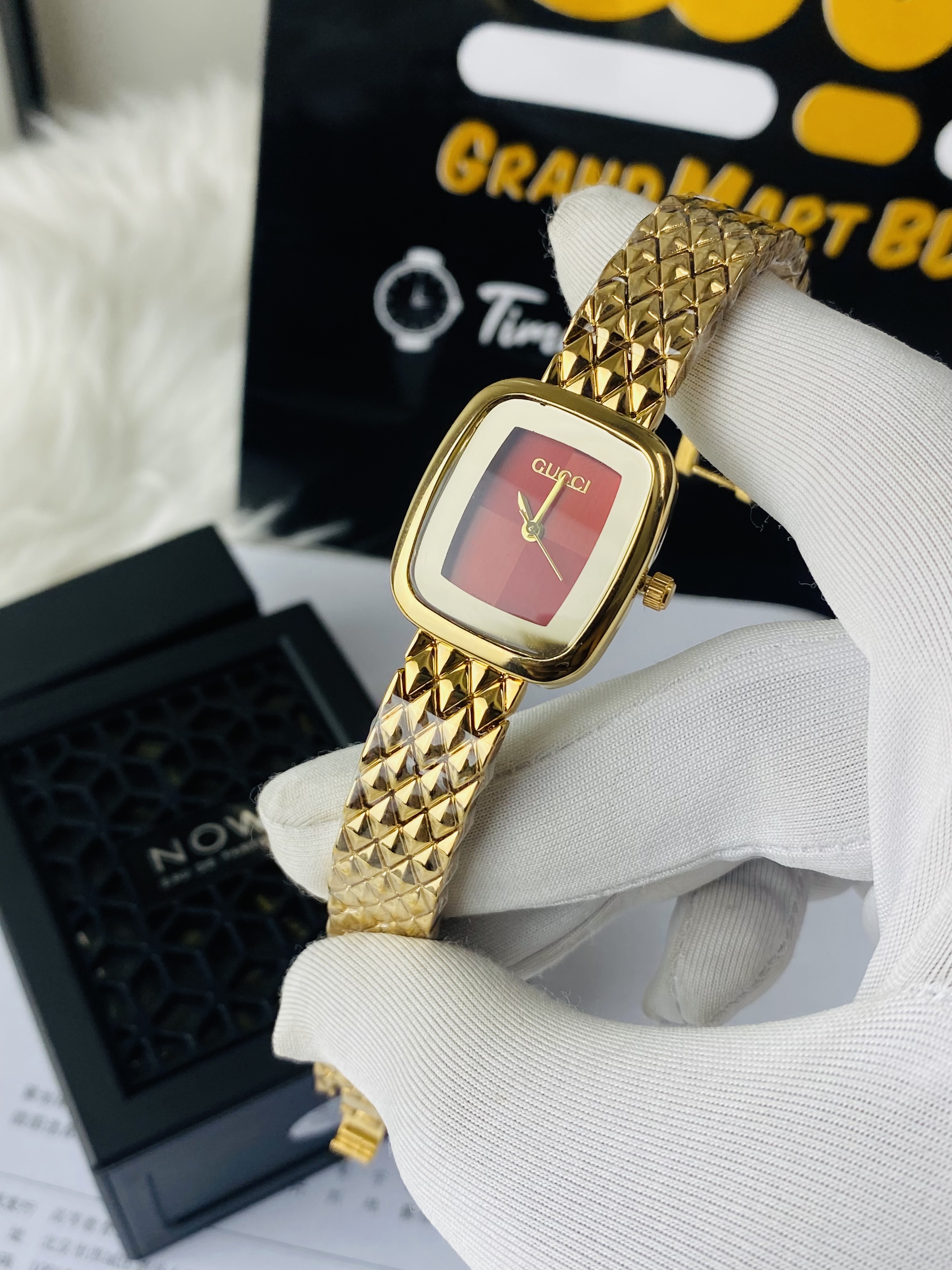 Two-tone Gucci Red dial watch with a square case and a patterned bracelet