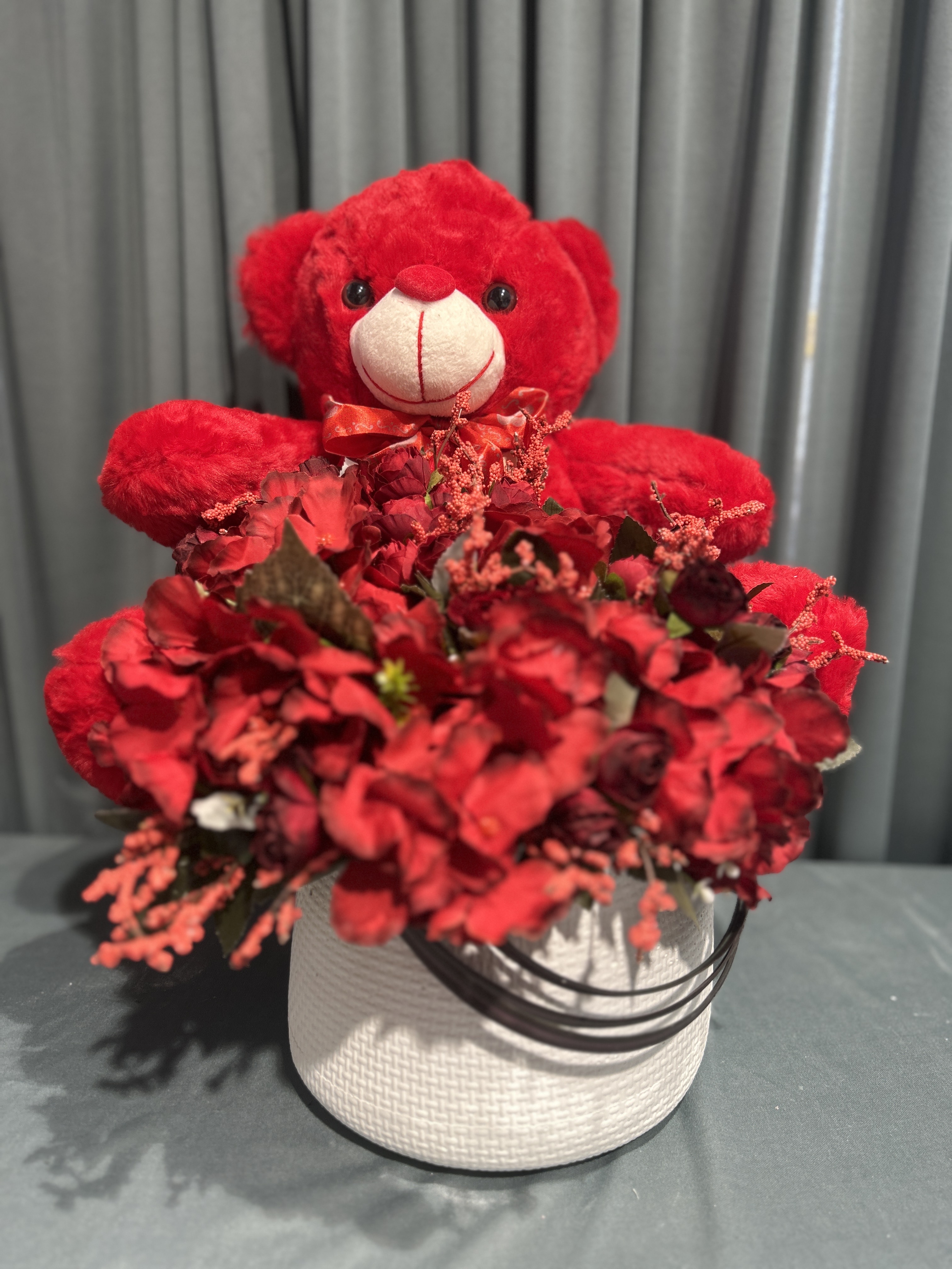 Teddy with red flowers vase