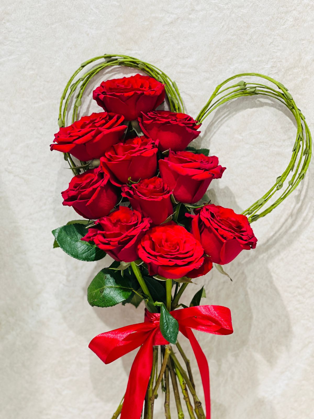 Red roses and steegrass heart shape hand bouquet